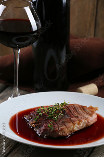 Grilled steak in wine sauce with glass of wine