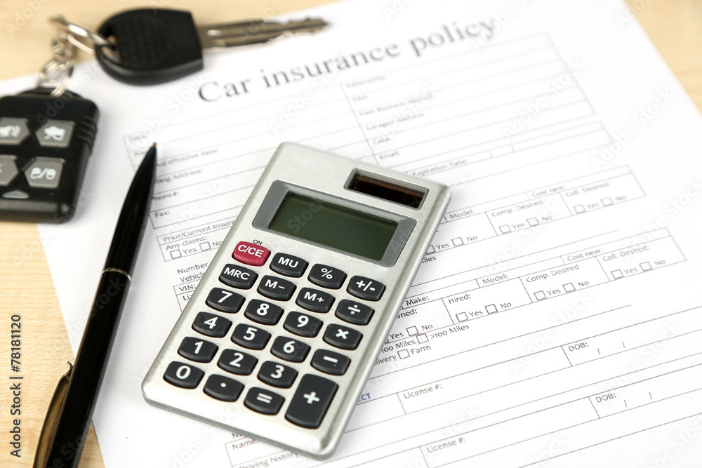 Car keys on insurance documents, close up Car keys on insurance documents, close up