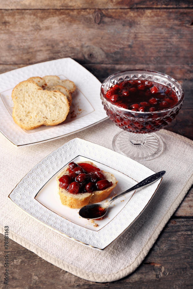 Fresh bread with jam on plate on wooden background Fresh bread with jam on plate on wooden background
