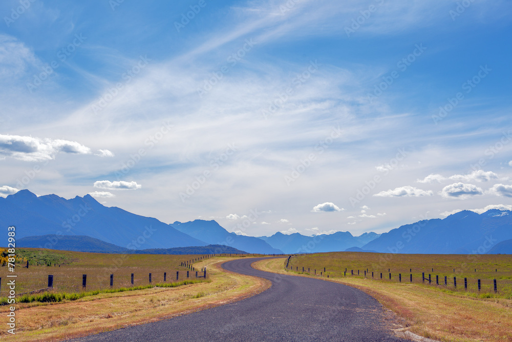 Pastoral winding country road and mountains in Fiordland, New Ze