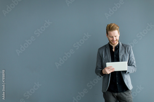 Man with tablet by the wall