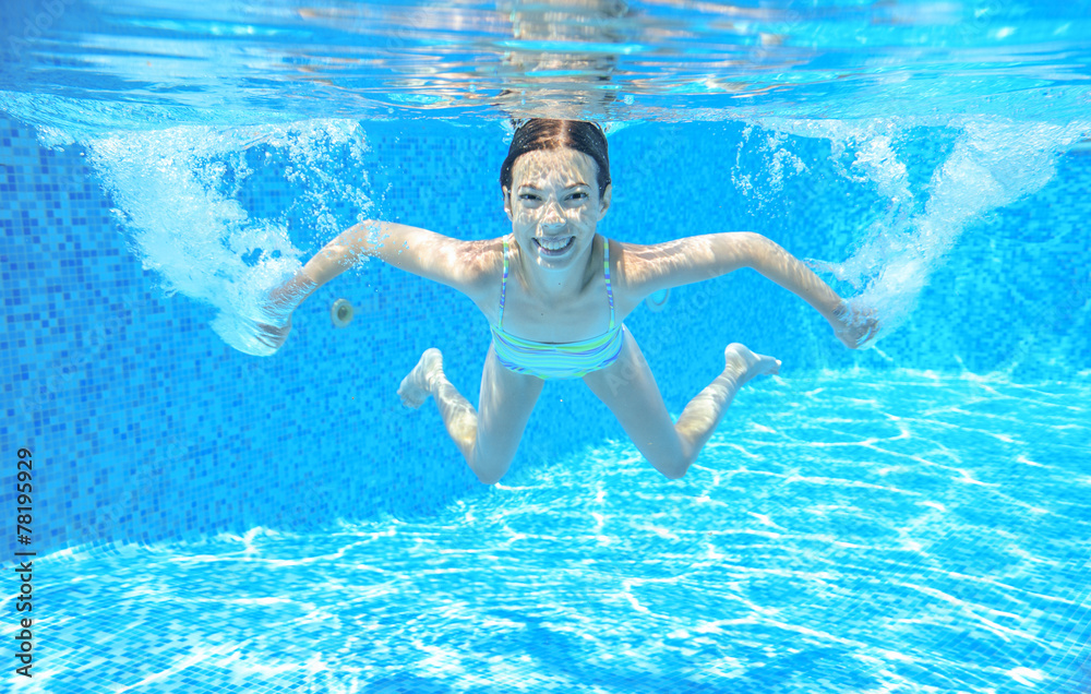 Kid swims in pool underwater, girl swimming having fun