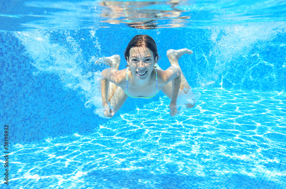 Kid swims in pool underwater, girl swimming having fun