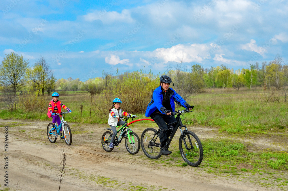 Happy family on bikes, father cycling with kids, family sport