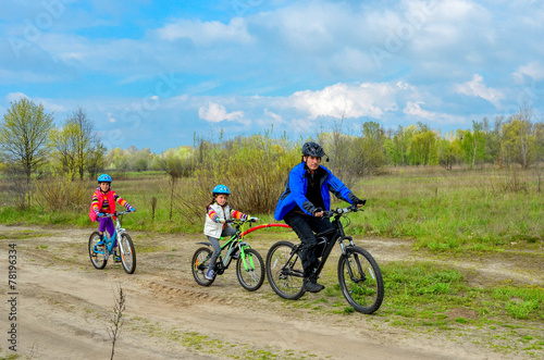 Happy family on bikes, father cycling with kids, family sport
