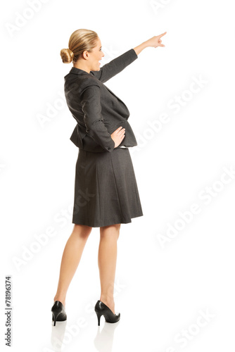 Businesswoman pointing high on copyspace