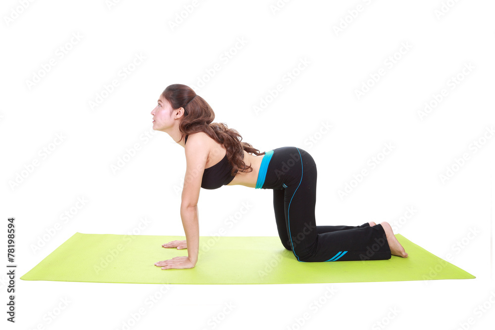 Obraz premium Young woman doing yoga exercise with yoga mat