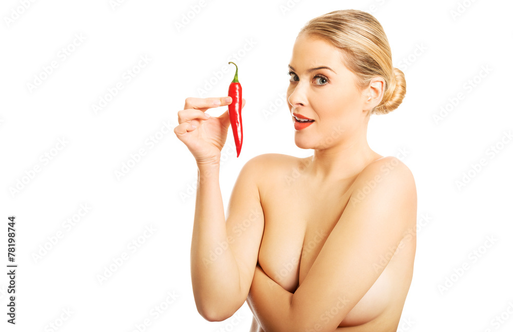 Fototapeta premium Woman holding chilli, looking at the camera