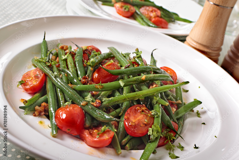 Green beans and tomato salad on white plate Green beans and tomato salad on white plate