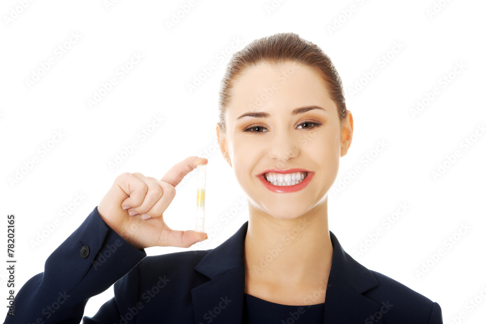 Beautiful businesswoman holding pill. Beautiful businesswoman holding pill.