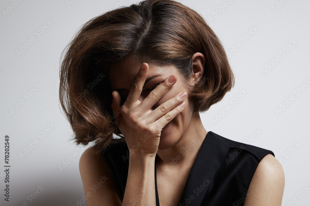 woman cover her face with a hand
