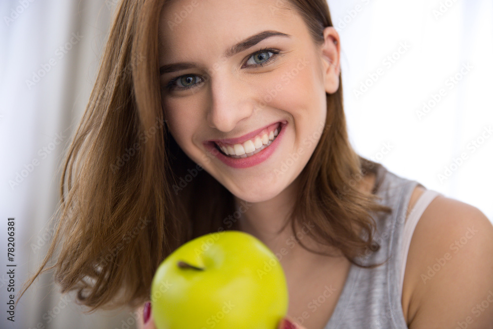 Closeup portrait of a smiling young woman with green apple Closeup portrait of a smiling young woman with green apple