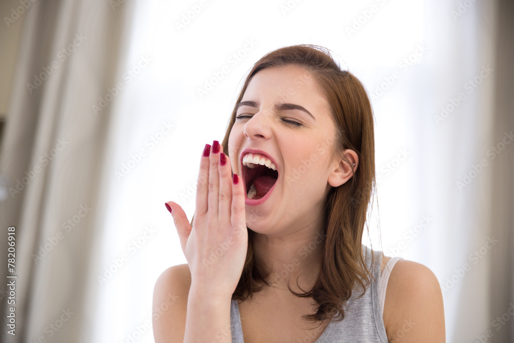 Young beautiful woman yawning at home Young beautiful woman yawning at home