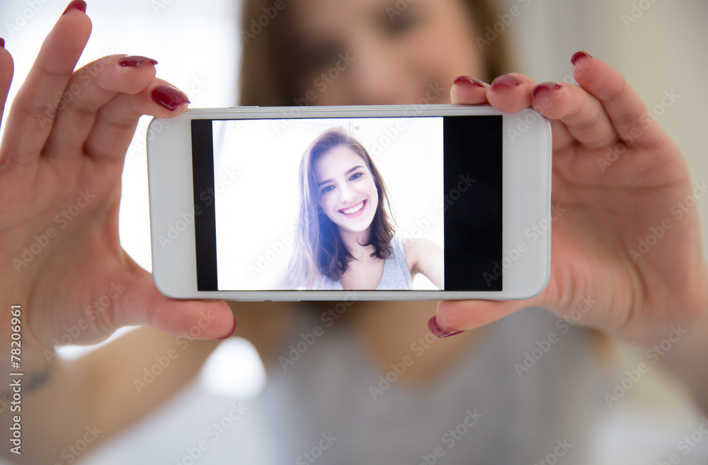 Cheerful woman making selfie photo on smartphone