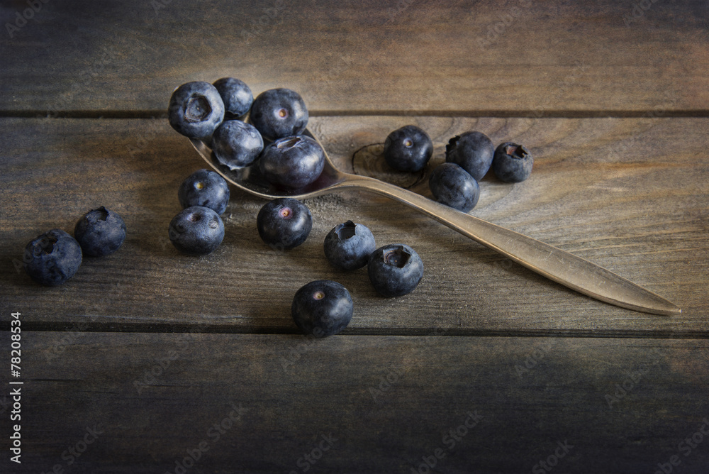 Blueberries in rustic kitchen setting with old wooden background