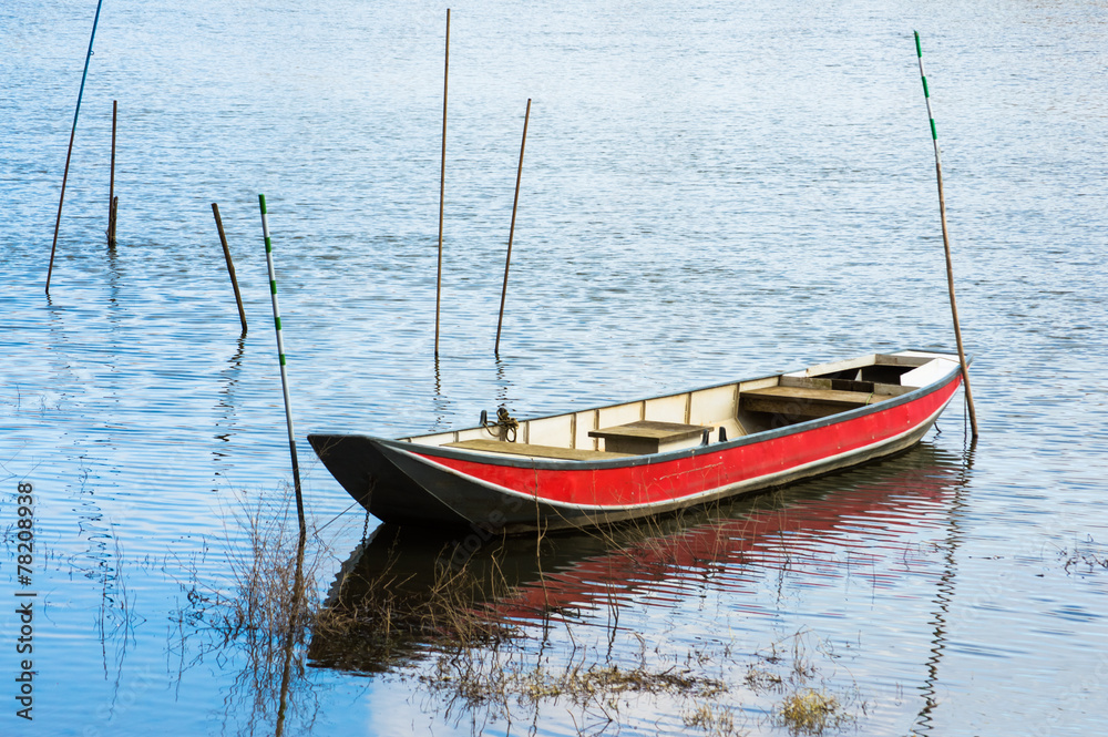 Red boat on a tranquil surface of a river