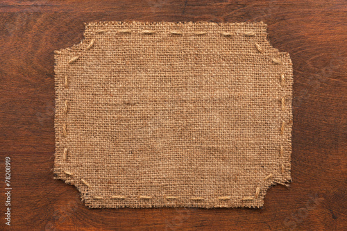 Frame of burlap, lies on a background of wood