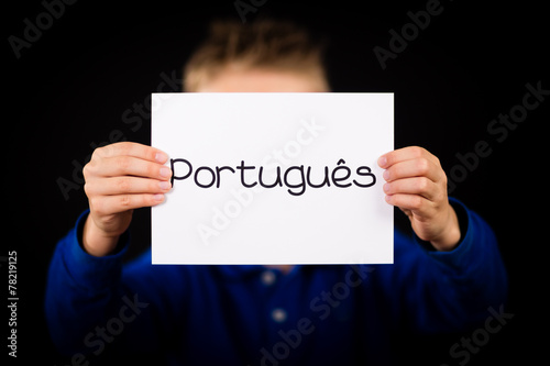 Child holding sign with Portuguese word Portugues - Portuguese i