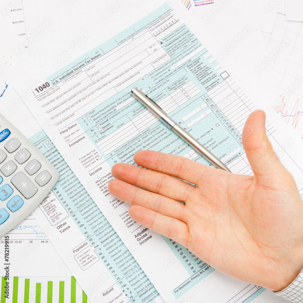 US 1040 Tax Form, calculator and male hand US 1040 Tax Form, calculator and male hand