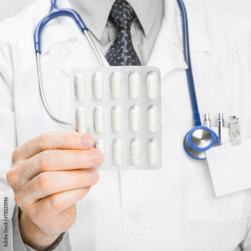 Doctor holdling pills in hand - heath care concept photo