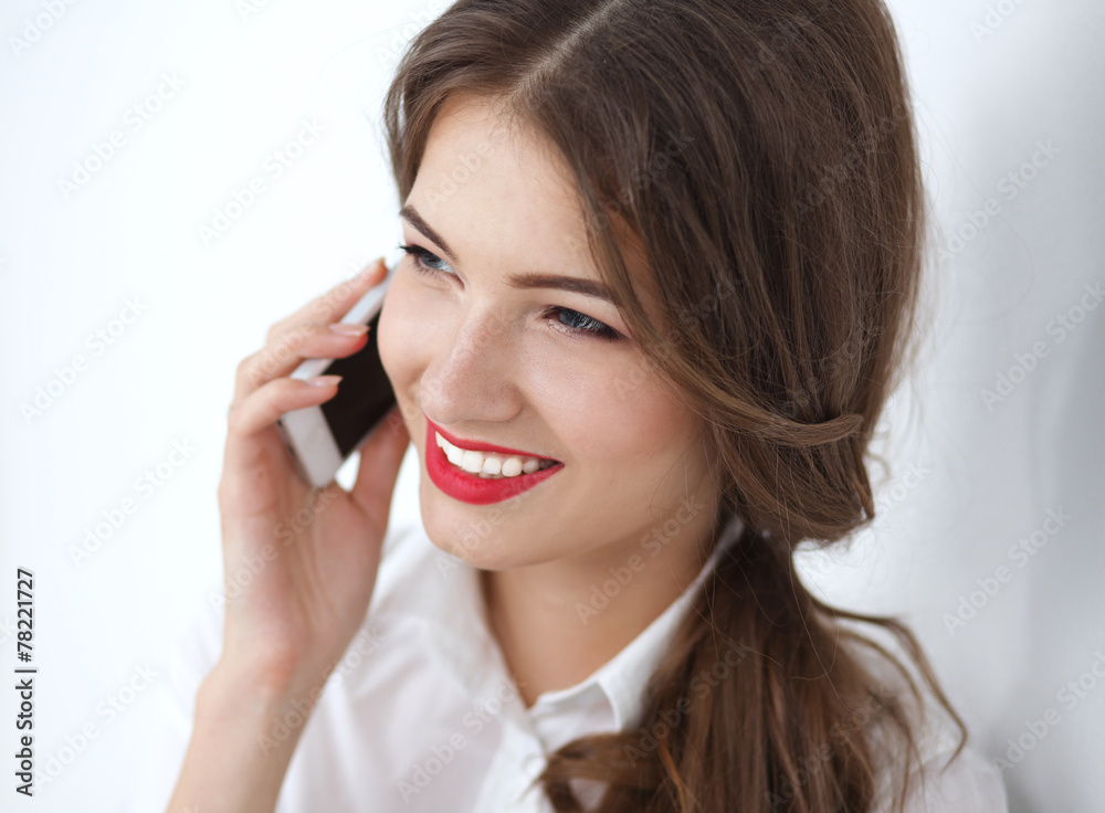 Smiling businesswoman talking on phone sitting at the office Smiling businesswoman talking on phone sitting at the office