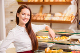 Beautiful young saleswoman in a bakery