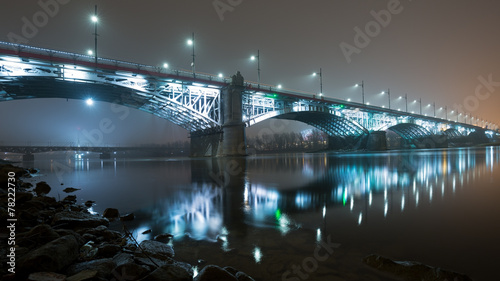 Bridge illuminated at night in the fog. Poniatowski Bridge