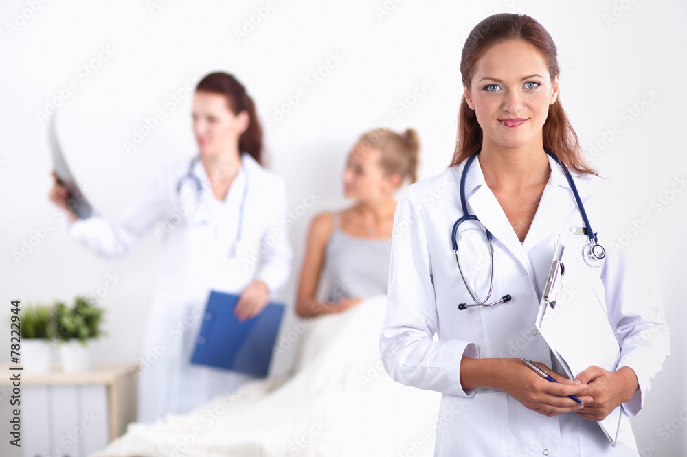Smiling female doctor with a folder in uniform standing at Smiling female doctor with a folder in uniform standing at
