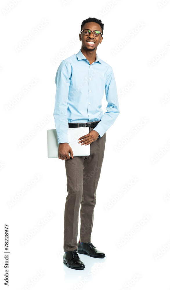 Happy african american college student standing with laptop on w