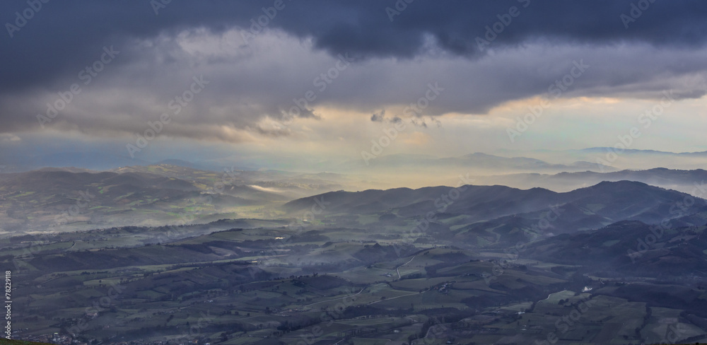 View of valleys just before a storm with clouds and fog, winter,