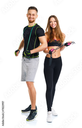 Happy sport couple - man and woman with with ropes on the white