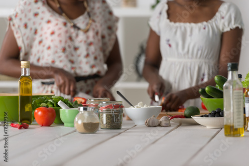 Two african women cooking salad