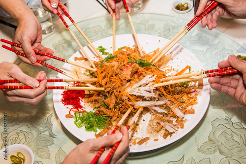 Tossing and mixing Yee Sang during Chinese New Year meal