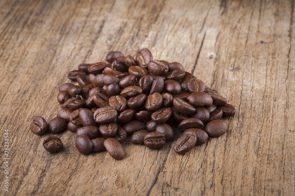 Fototapeta premium roasted coffee beans in wooden spoon placed on coffee beans as b