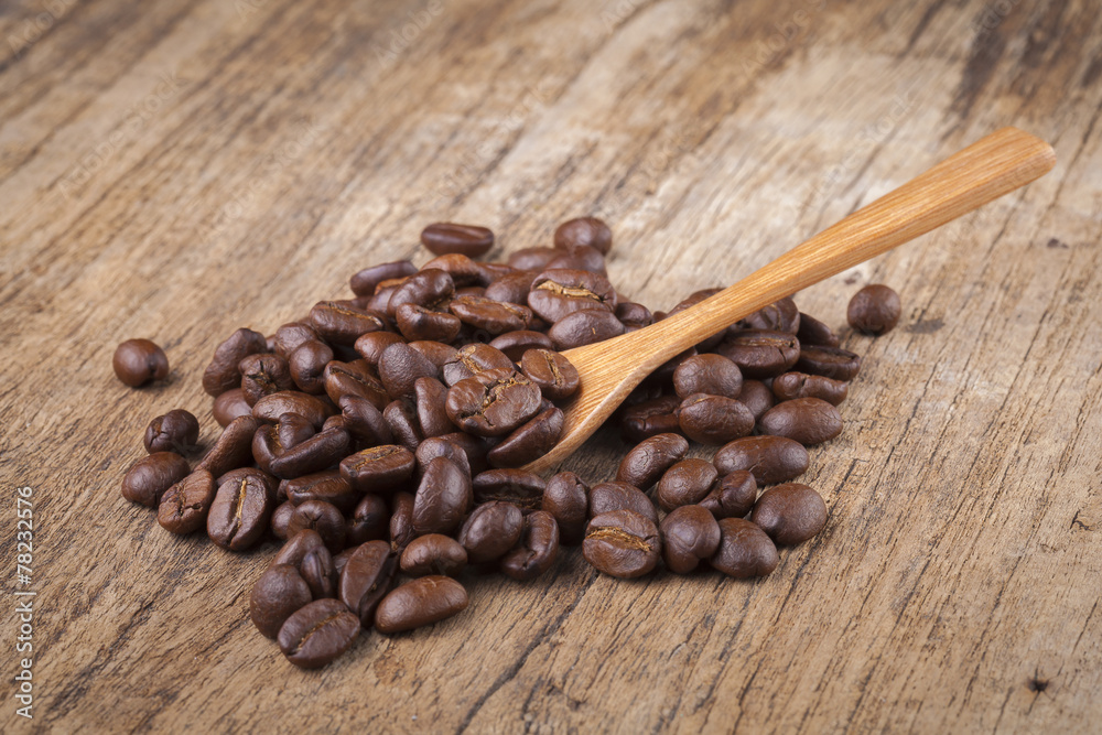 roasted coffee beans in wooden spoon placed on coffee beans as b roasted coffee beans in wooden spoon placed on coffee beans as b
