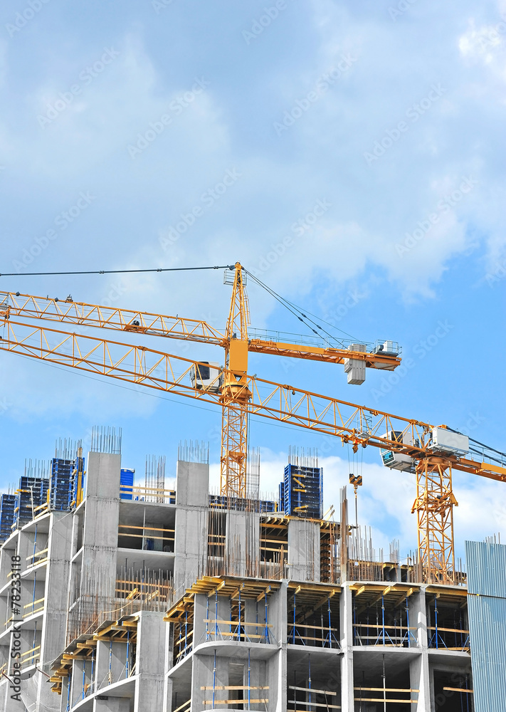 Crane and building construction site against blue sky