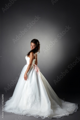 Modest bride posing in elegant dress with plume