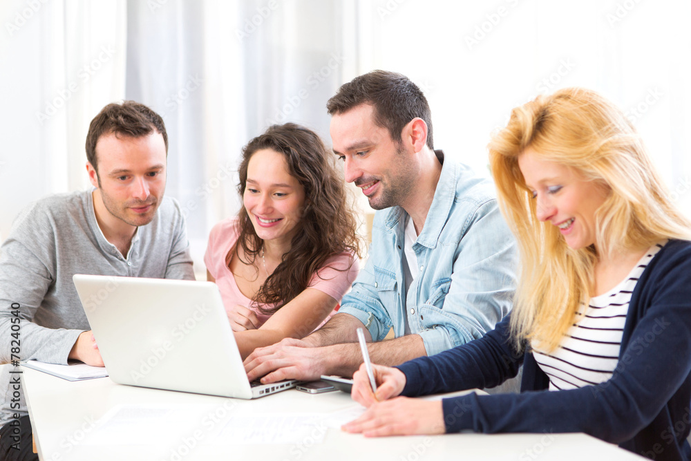 Group of 4 young attractive people working on a laptop
