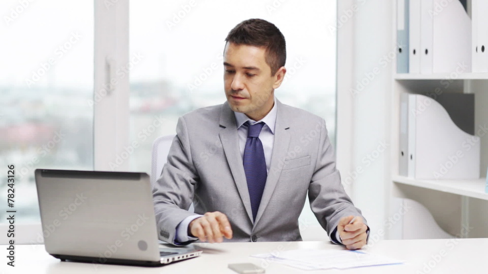 smiling businessman with laptop and papers smiling businessman with laptop and papers