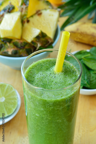 Green spinach and pineapple smoothie on table.