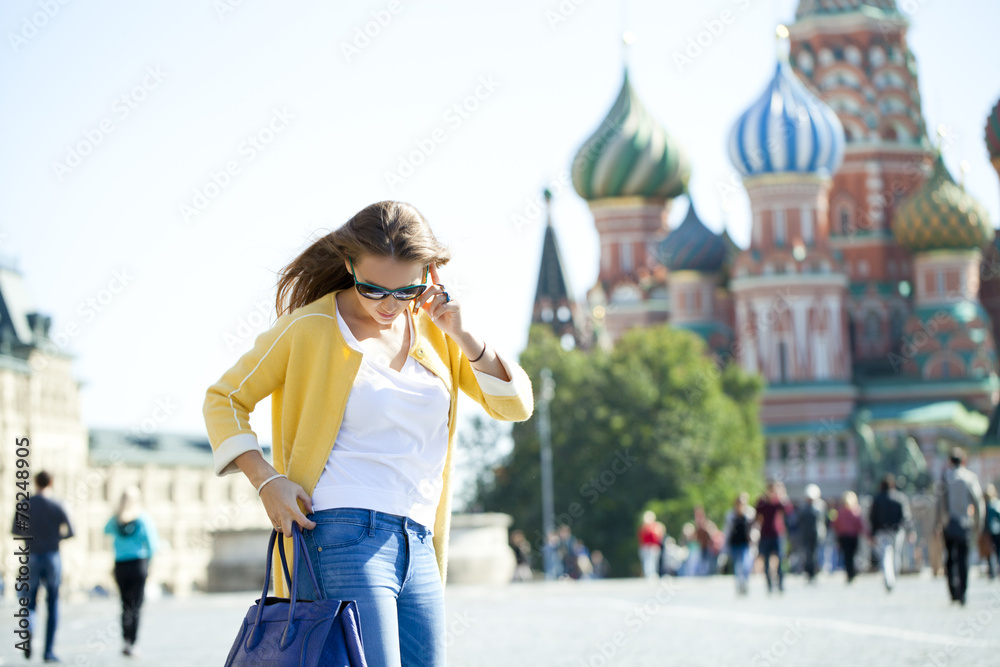 Young beautiful happy woman calling by phone in Moscow