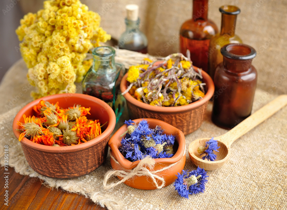 Healing herbs and tinctures in bottles on sackcloth Healing herbs and tinctures in bottles on sackcloth