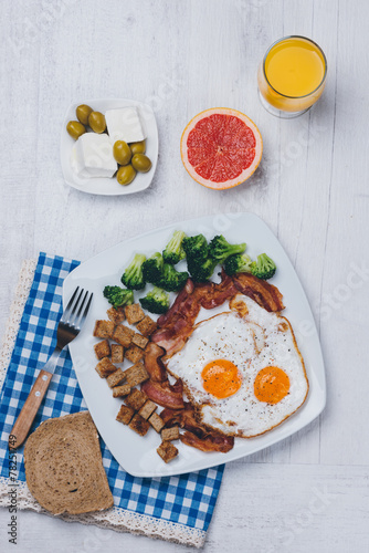 Fried eggs and bacon with broccoli and croûtons