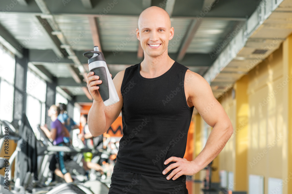 Young athletic young man holding a sports bottle Young athletic young man holding a sports bottle