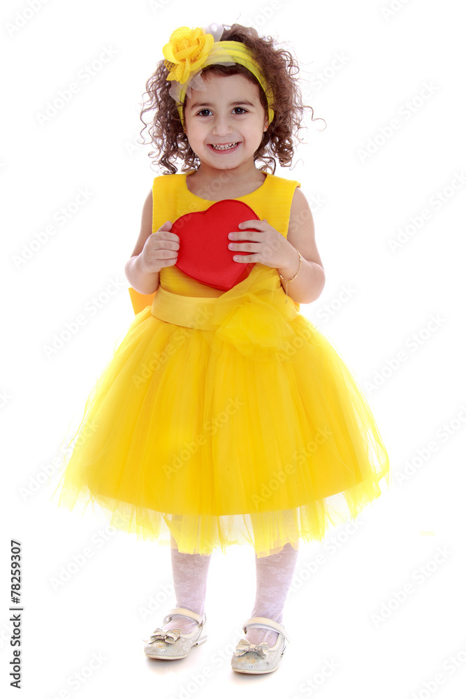 Beautiful curly-haired little girl in a yellow dress cuddle hear Beautiful curly-haired little girl in a yellow dress cuddle hear