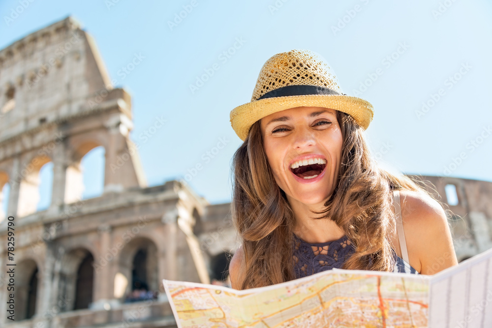 Portrait of happy woman with map in front of colosseum  in Rome