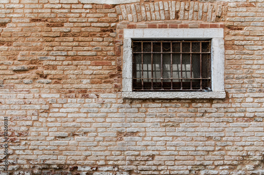Ancient brick wall texture. Window with grill and railings. Ancient brick wall texture. Window with grill and railings.