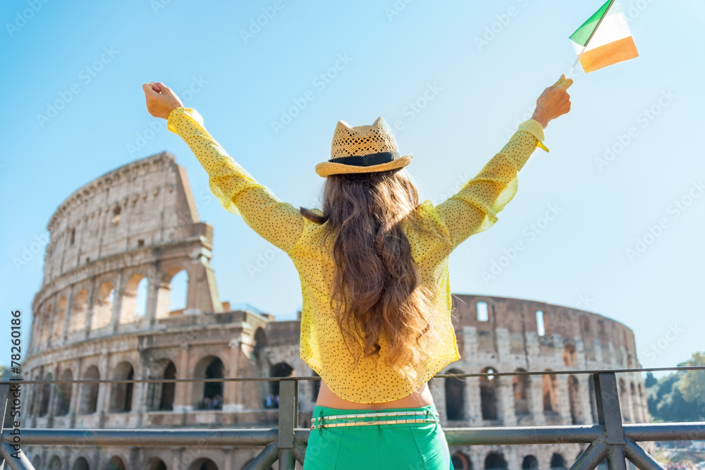 Young woman with italian flag rejoicing in front of colosseum