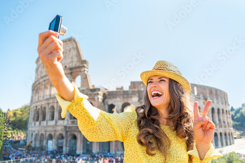 Photography Happy young woman making selfie in front of colosseum in rome