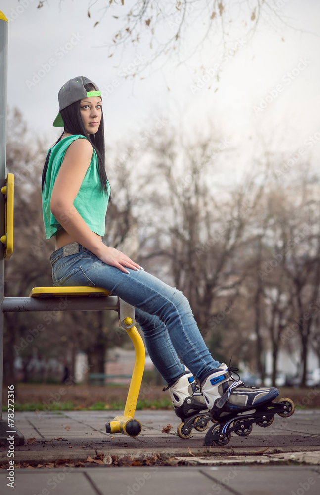 Obraz premium Girl sitting on gym machine with roller blades